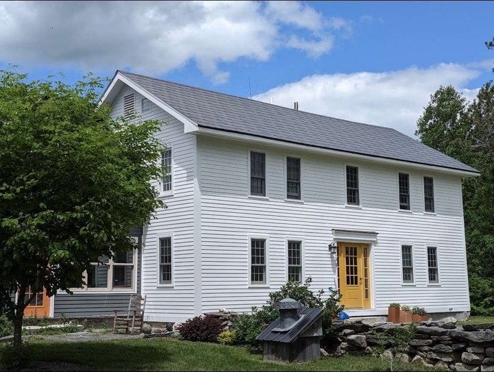 Roofing on a white two-story home